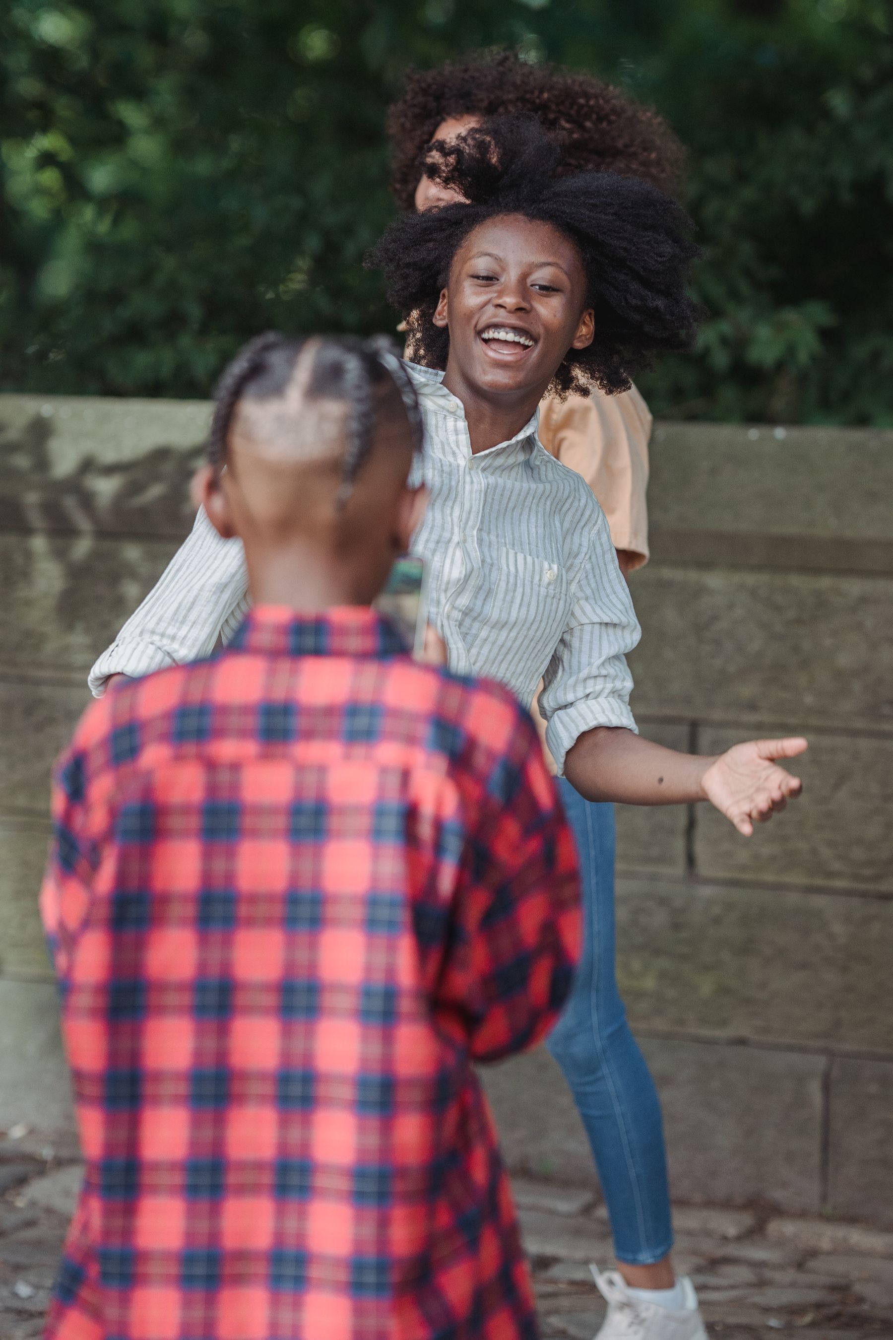 Une mère rit en jouant avec ses enfants dans un parc