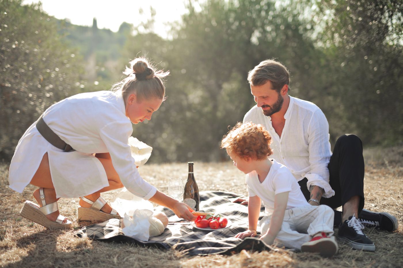 Une famille prépare un pique-nique au soleil avec son enfant